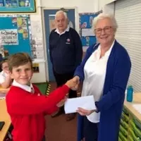 Penelope receiving a donation from one of the pupils